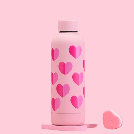Pink thermos bottle with heart patterns on a pink background