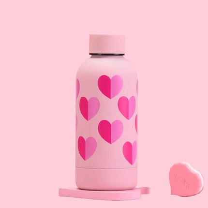 Pink water bottle with heart patterns on a pink background