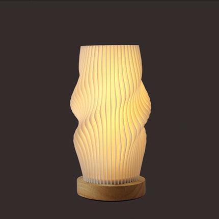 Decorative table lamp with wavy design on a dark background
