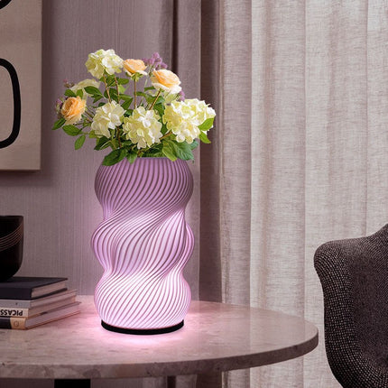 Decorative lamp with floral arrangement on a table against a curtain backdrop