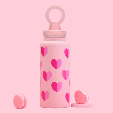 Pink water bottle with heart patterns on a pink background
