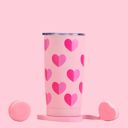 Pink tumbler with heart pattern on a pink background
